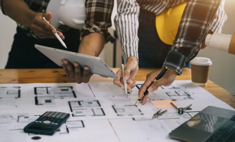 Person's engineer Hand Drawing Plan On Blue Print with architect Person's engineer Hand Drawing Plan On Blue Print with architect equipment, Architects discussing at the table, team work and work flow construction concept.